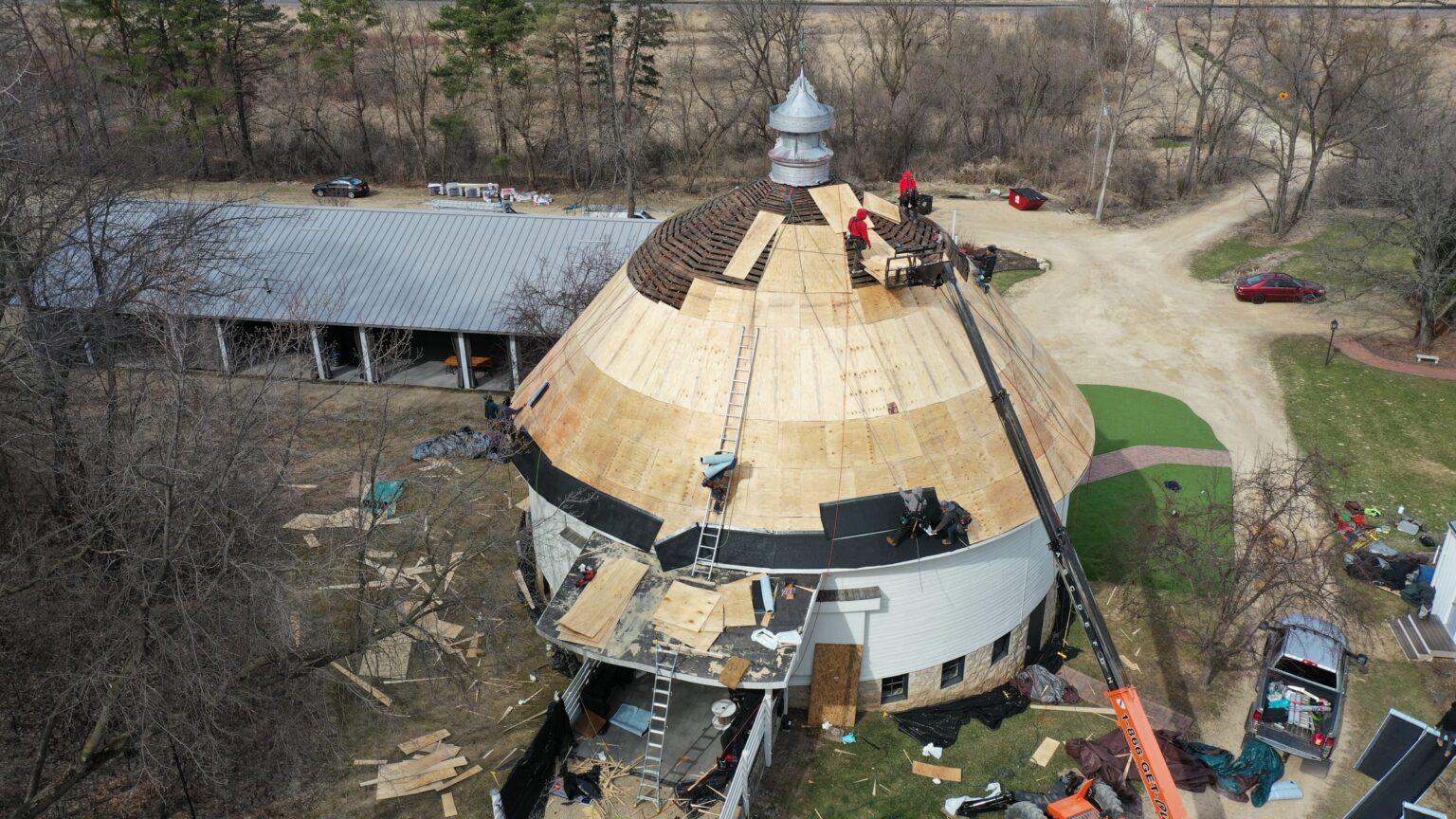 Round barn roof restoration in progress, aerial view