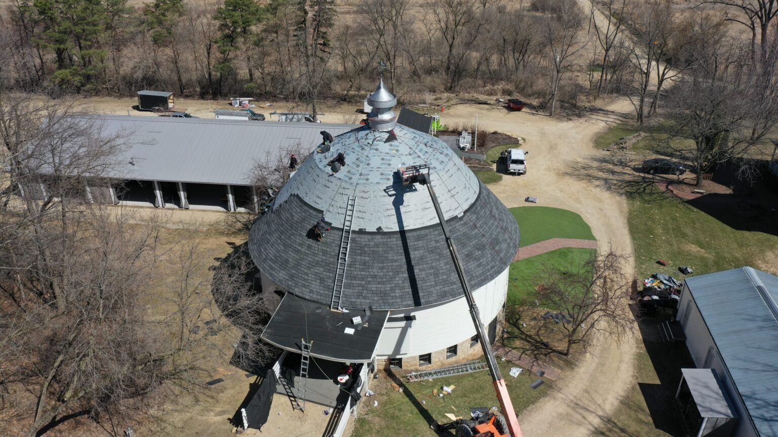 Synthetic underlayment installed on the round barn dome with shingling starting at the eaves